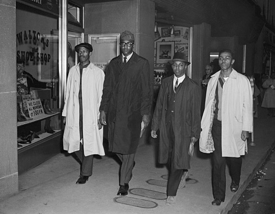 This is a photograph of the Greensboro Four, the four black men who initiated the protest movement of sit-ins in North Carolina by refusing to leave the lunch counter at Woolworth in Greensboro, North Carolina on February 1, 1960. 