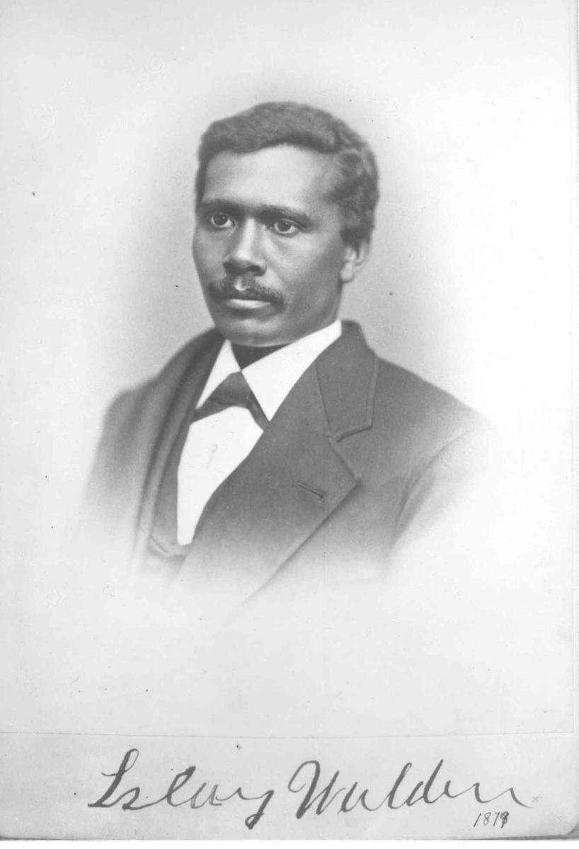 Black and white photo of a man wearing a suit. He has a calm expression on his face. Photograph is labeled "Islay Walden 1879" in cursive handwriting at bottom of image. 