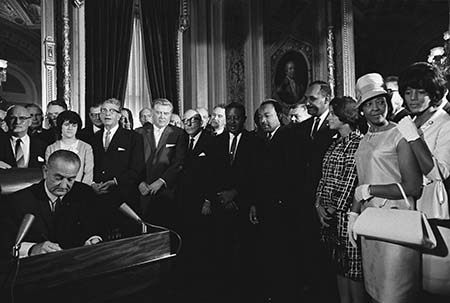 President Lyndon B. Johnson signs the Voting Rights Act as Martin Luther King Jr. and other civil rights leaders look on, August 6, 1965, United States Capitol, Washington, D.C.