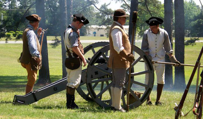Image or reenactors at the Alamance Battleground, with a cannon