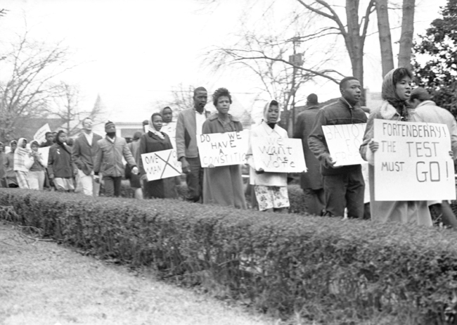 The is a photograph of Men and women in McComb, Mississippi march in a demonstration for voting rights in 1962.