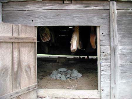 Photograph of the interior of a traditional North Carolina smokehouse at the Cedarock Historical Farm in Alamance County, N.C. Image from the N.C. ECHO Project in the N.C. Digital Collections, N.C. Department of Natural and Cultural Resources.