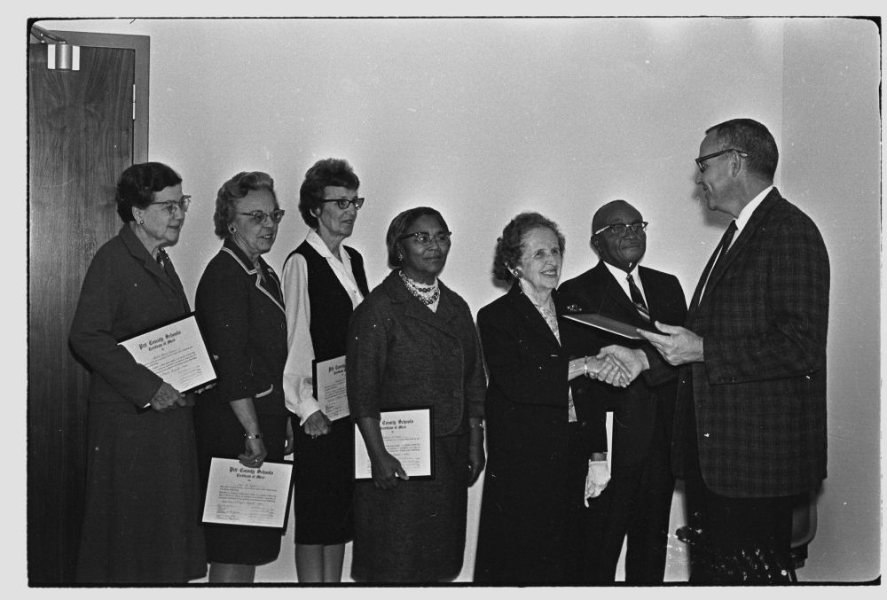 Photograph of Pitt County Schools Superintendent Arthur S. "Ott" Alford (far right) presenting certificates to school system faculty and staff. This photograph is from the Daily Reflector Image Collection at ECU and is for use only in research, teaching, and private study. 