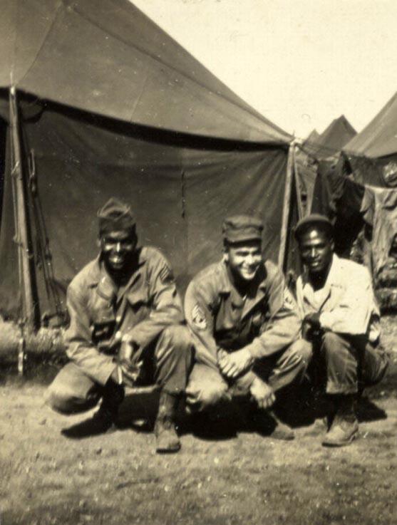 Soldiers at Fort Francis E. Warren, Wyoming (1943) This is a black and white print of soldiers crouching with tents in the background, Fort Francis E. Warren, Wyoming, 1943. Soldiers from left to right are "unidentified," First Sergeant Southall, and Staff Sergeant Odra W. Bradley.