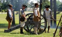 Image of re-enactors preparing a cannon at Alamance Battleground Historic Site in Alamance County, N.C.  After several years of increasing rebellion and violence from backcountry residents protesting fees and government corruption, Governor Tryon sent militia to deal with the Regulators at Alamance in May of 1771.  The battle occurred on May 16, with Tryon's military taking the victory.  Several Regulators were taken captive and charged, and 6 were hanged. 