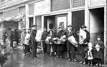 A group of men, women and children outside the Salvation Army with bags, baskets, and toys for the Christmas Revival campaign, Greensboro, N.C., circa 1920-1940). Image from the North Carolina State Archives.