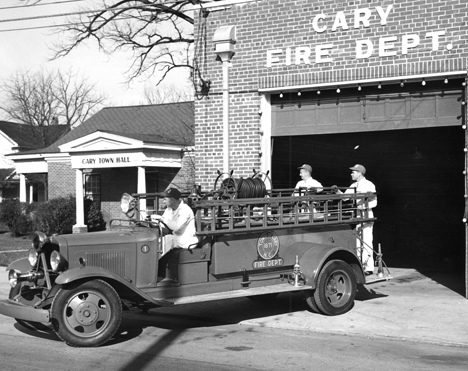 Three unidentified men with fire truck in front of the Cary, NC, Fire Department building, no date. From Carolina Power and Light (CP&L) Photograph Collection (Ph.C.68), North Carolina State Archives, call #:  PhC68_1_549_1. 