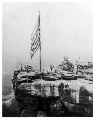 Visitors saluting the flag on Chimney Rock, ca. 1920s.  From the North Carolina State Parks Collection, North Carolina Digital Collections.  Used courtesy of North Carolina State Parks.