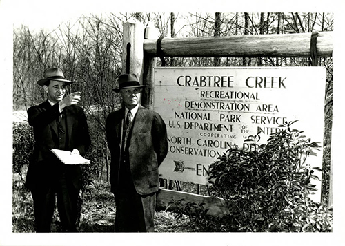 Fred Johnson (left) and Bruce Etheridge in 1943 at the transfer of Crabtree Creek Recreational Demonstration Area from the National Park Service to the North Carolina Division of State Parks. From the North Carolina State Parks Collection, NC Digital Collections.