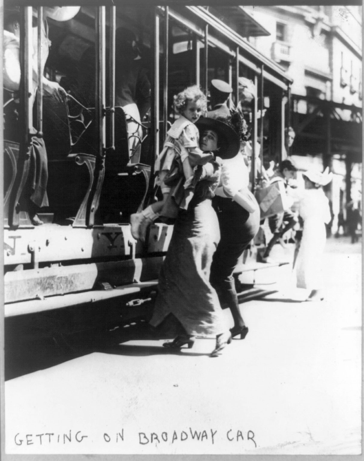 A women helps a child into a trolley car.