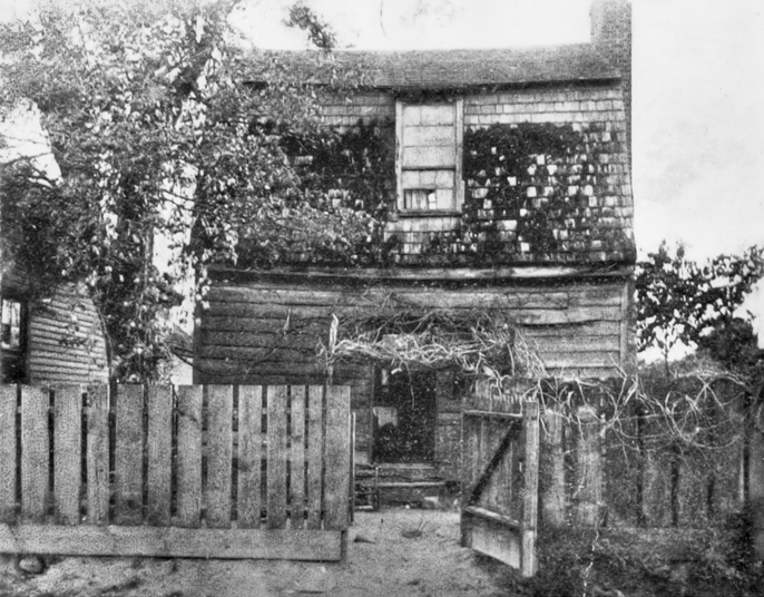 Andrew Johnson's birthplace, ca. 1906. The photograph was likely taken before the house was moved from its original site. North Carolina Collection, University of North Carolina at Chapel Hill Library.