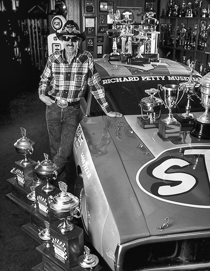 Richard Petty with one of his race cars and some of his many trophies in the Petty Museum at Level Cross. Photograph courtesy of the North Carolina Division of Tourism, Film, and Sports Development.