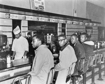 Students from North Carolina Agricultural and Technical College sit in at the whites-only lunch counter at the F. W. Woolworth store in downtown Greensboro on 1 Feb. 1960. Left to right: Ezell Blair, Franklin McCain, David Richmond, and Joseph McNeil. Greensboro News and Record.