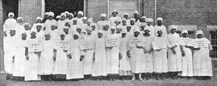 North Carolina's “first class of law controlled and class instructed midwives” on the steps of the Beaufort County Courthouse, 1925. Several of the women hold signs printed with lessons they have learned, such as “The New Midwife Must Be Clean” and “We Must Report the Baby's Birth.” North Carolina Collection, University of North Carolina at Chapel Hill Library.