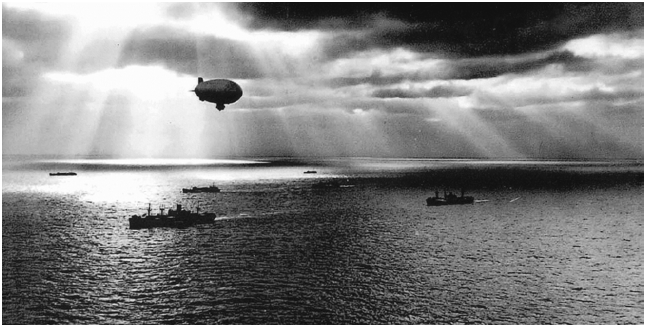 A U.S. Navy blimp flies over a convoy of ships to protect it from German U-boats. Image courtesy of Stephen D. Chalker.